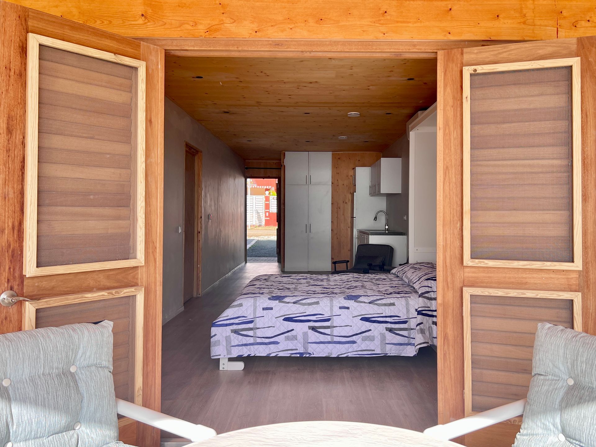 Cozy oceanfront studio in Curaçao with queen-size bed, kitchen area, and open terrace overlooking the Caribbean Sea