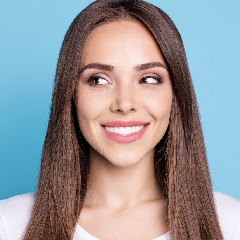 A woman with long brown hair is smiling for the camera.