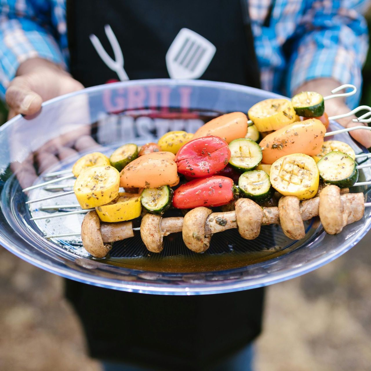 A person is holding a plate of food that says grill master on it