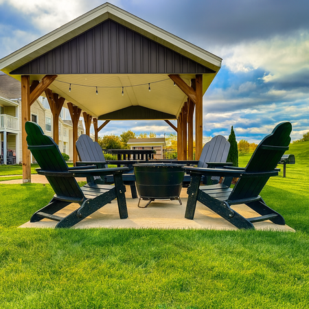 Four black Adirondack chairs around a fire pit under a gazebo on a grassy lawn.