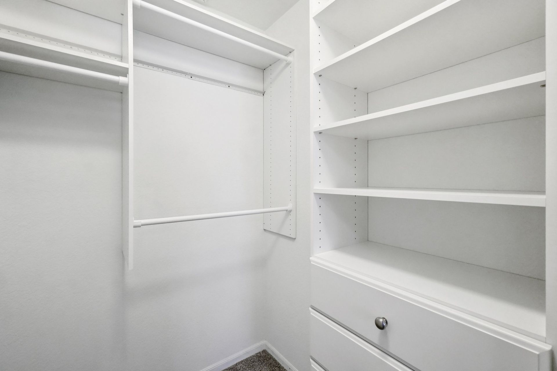 Empty white closet with shelves and drawers.
