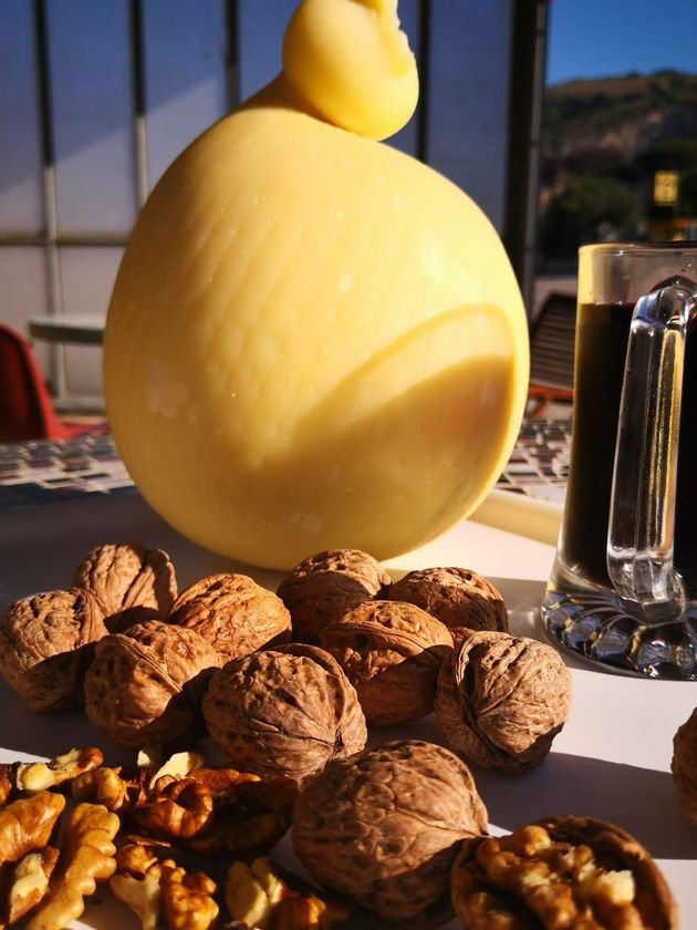 Un grosso formaggio giallo, noci con e senza guscio