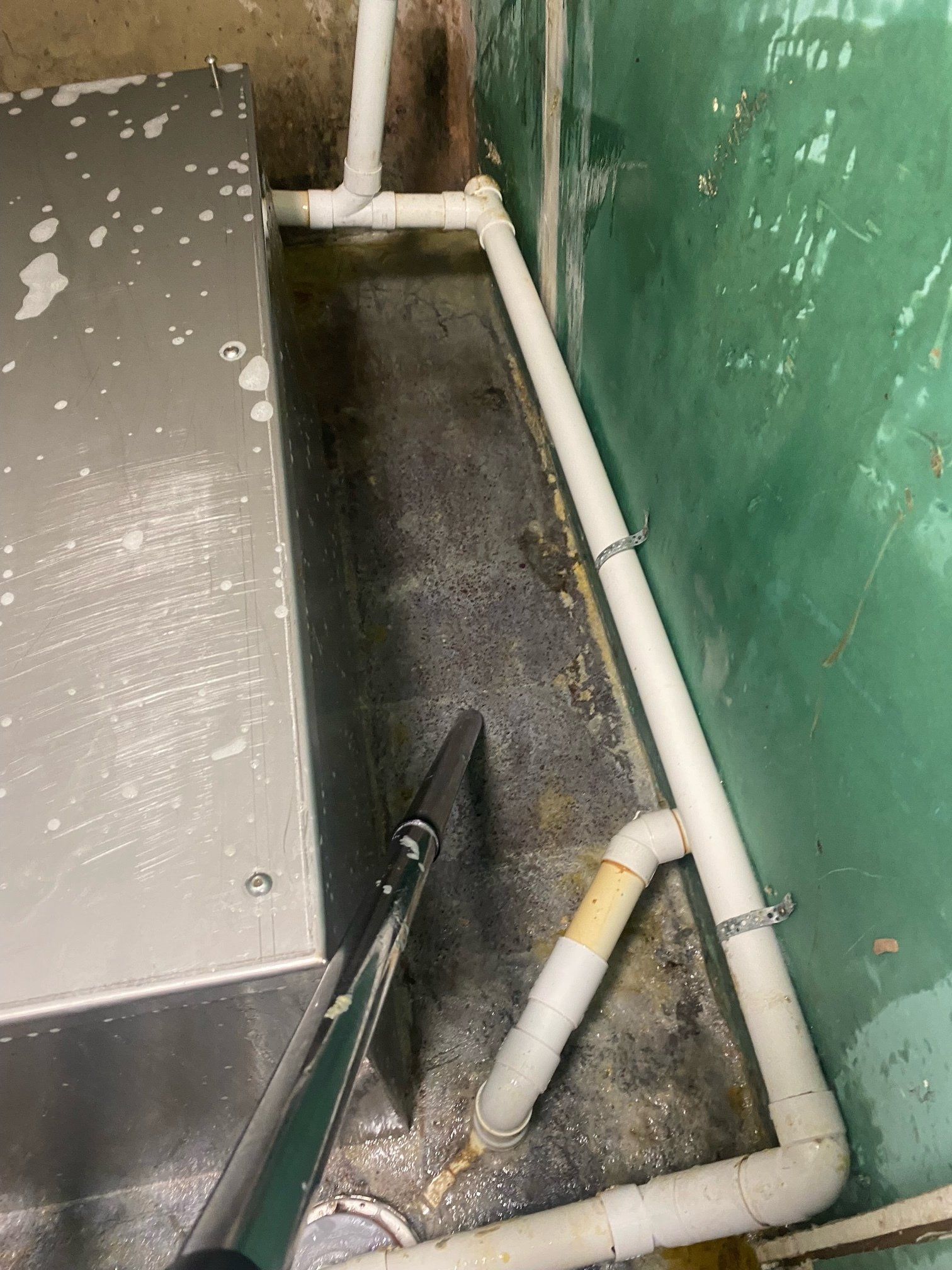 A close up of a pipe in a room next to a wall.