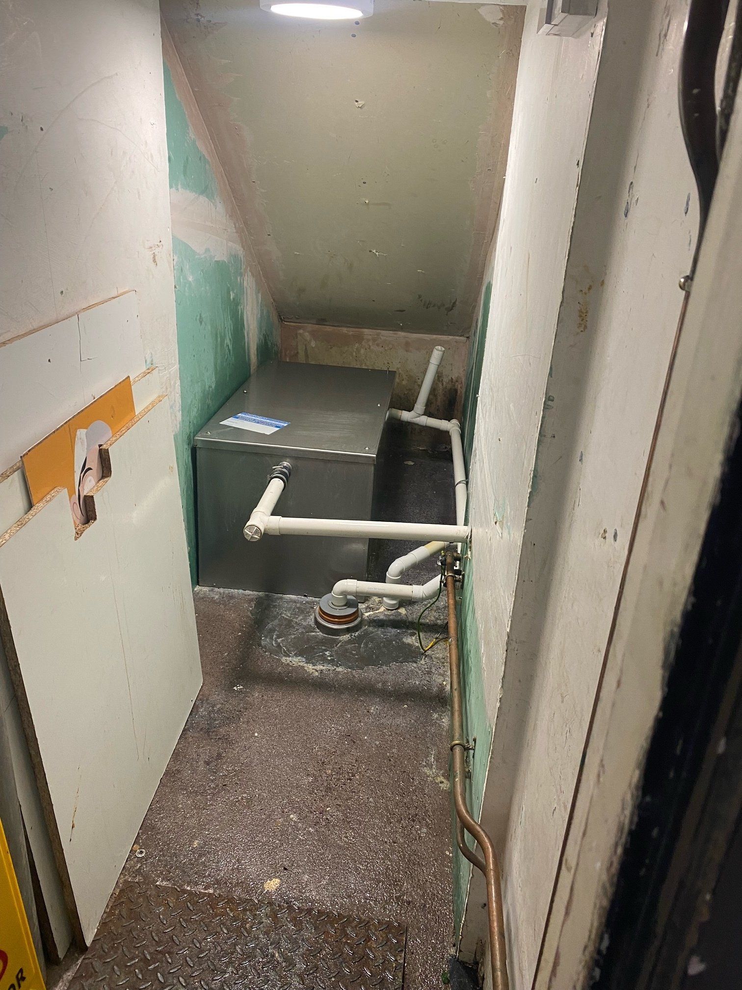 A room with a heater and pipes in it.