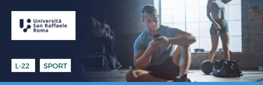 Un uomo è seduto sul pavimento di una palestra e guarda il telefono. Un'altra persona è sullo sfondo. Sono visibili loghi e testo.