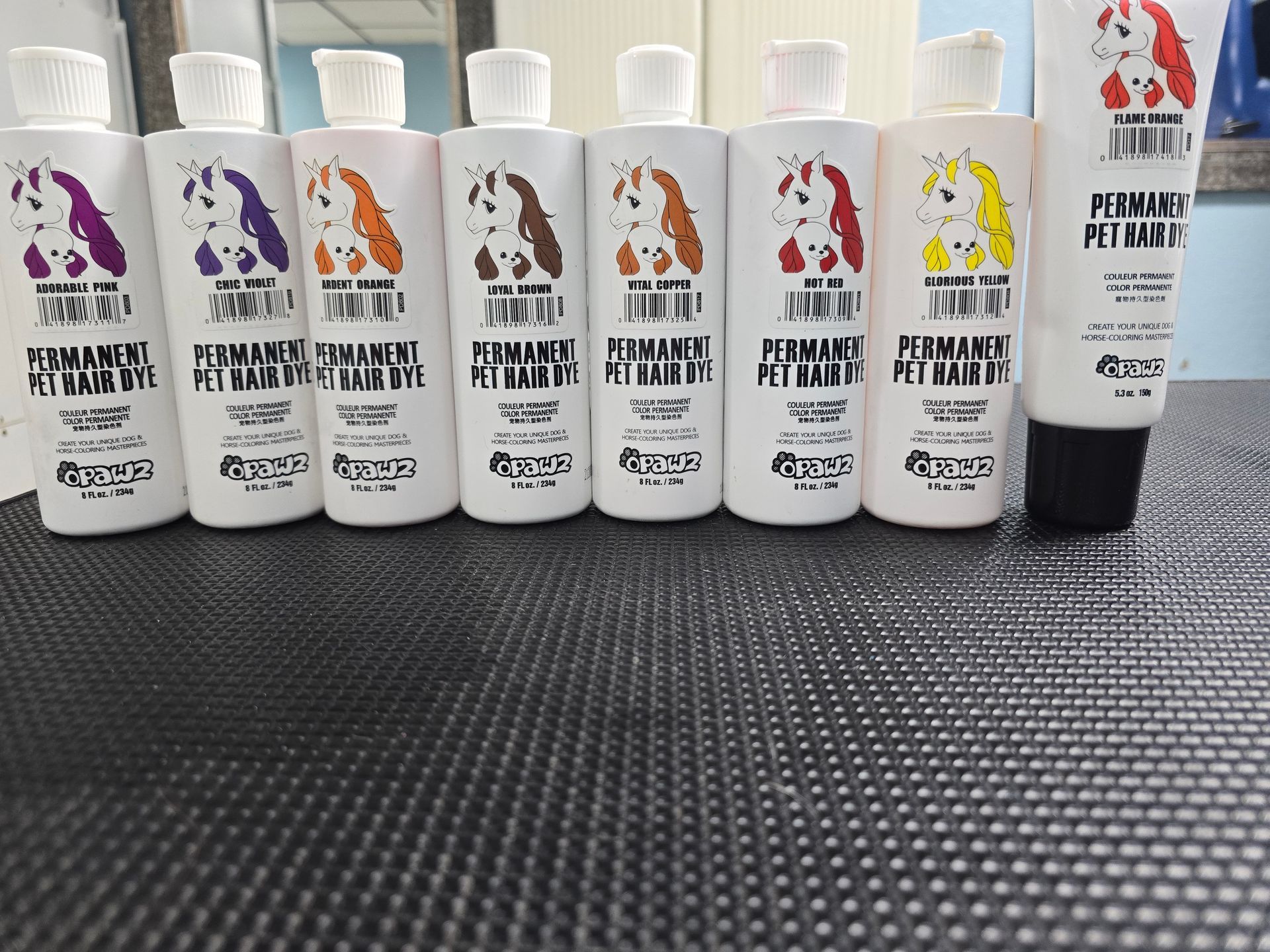 A row of pet shampoo bottles are lined up on a table