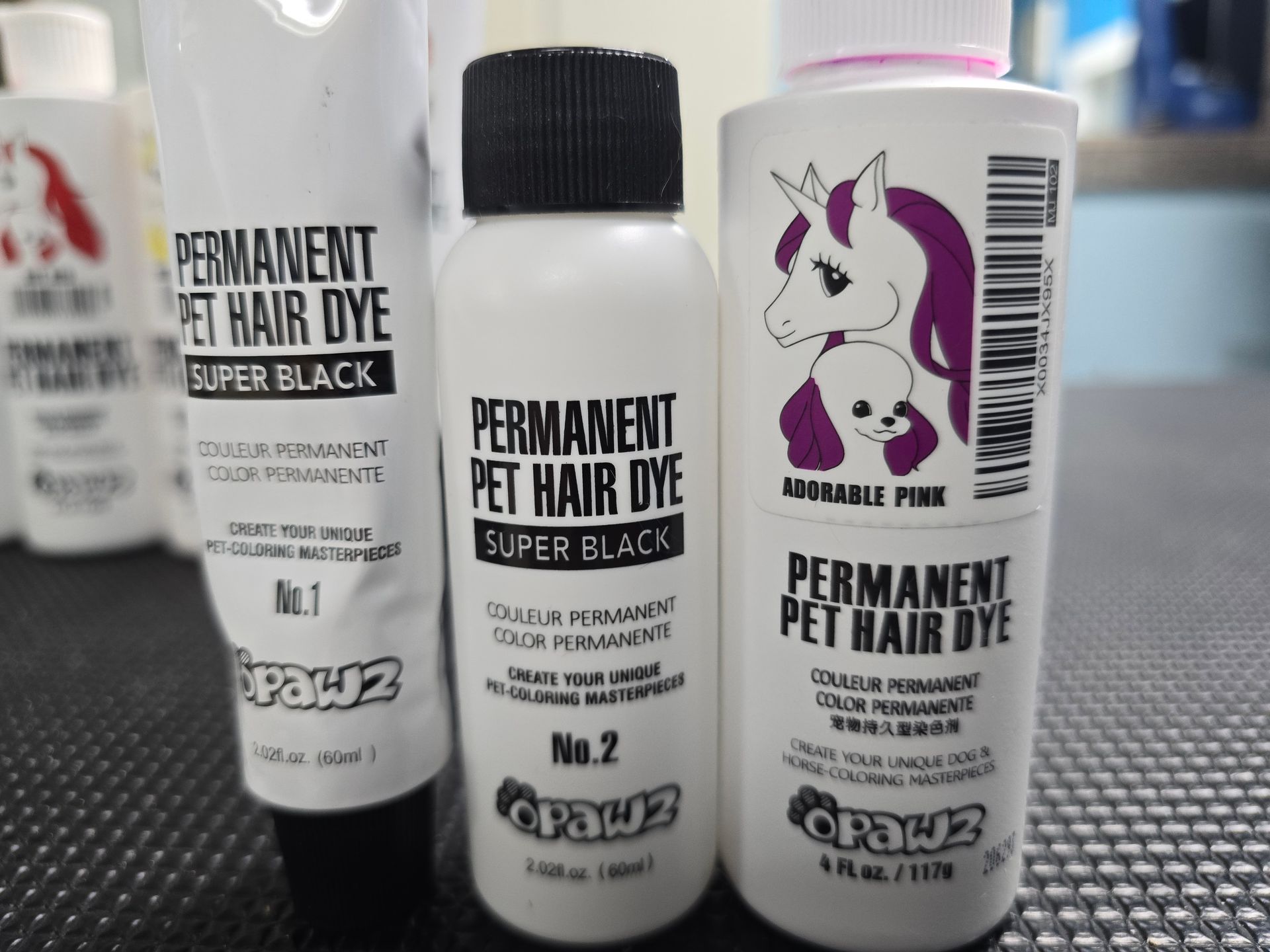 Three bottles of permanent pet hair dye sit on a table