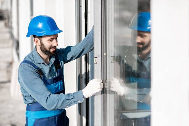 A man wearing a hard hat is installing a window.