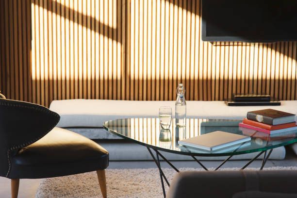 A living room with a glass coffee table and a chair