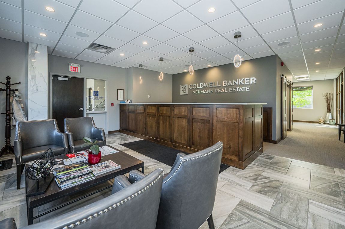 A waiting room with chairs, a coffee table, and a counter.