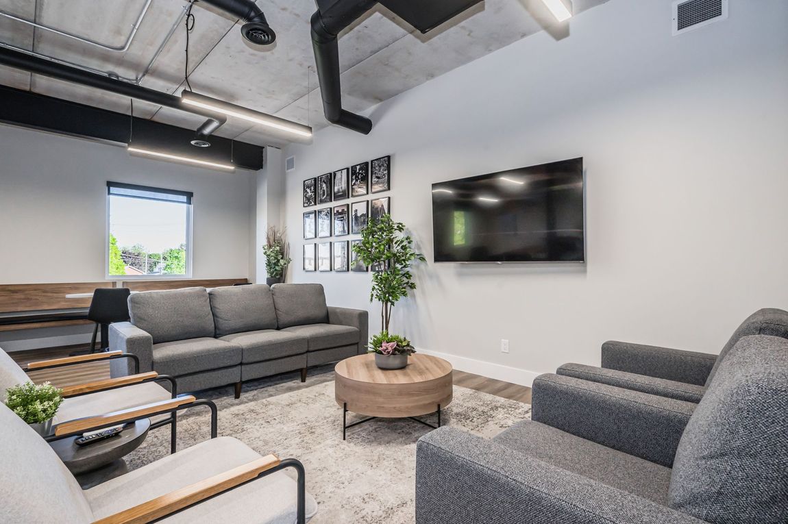 A living area with seating and a flat screen tv.