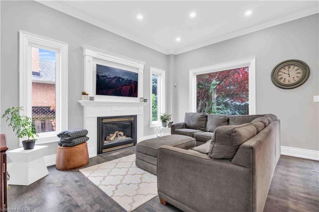 A living room with a large couch, fireplace and television.