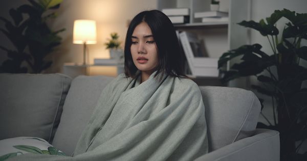 a person on couch sick because of a cold house