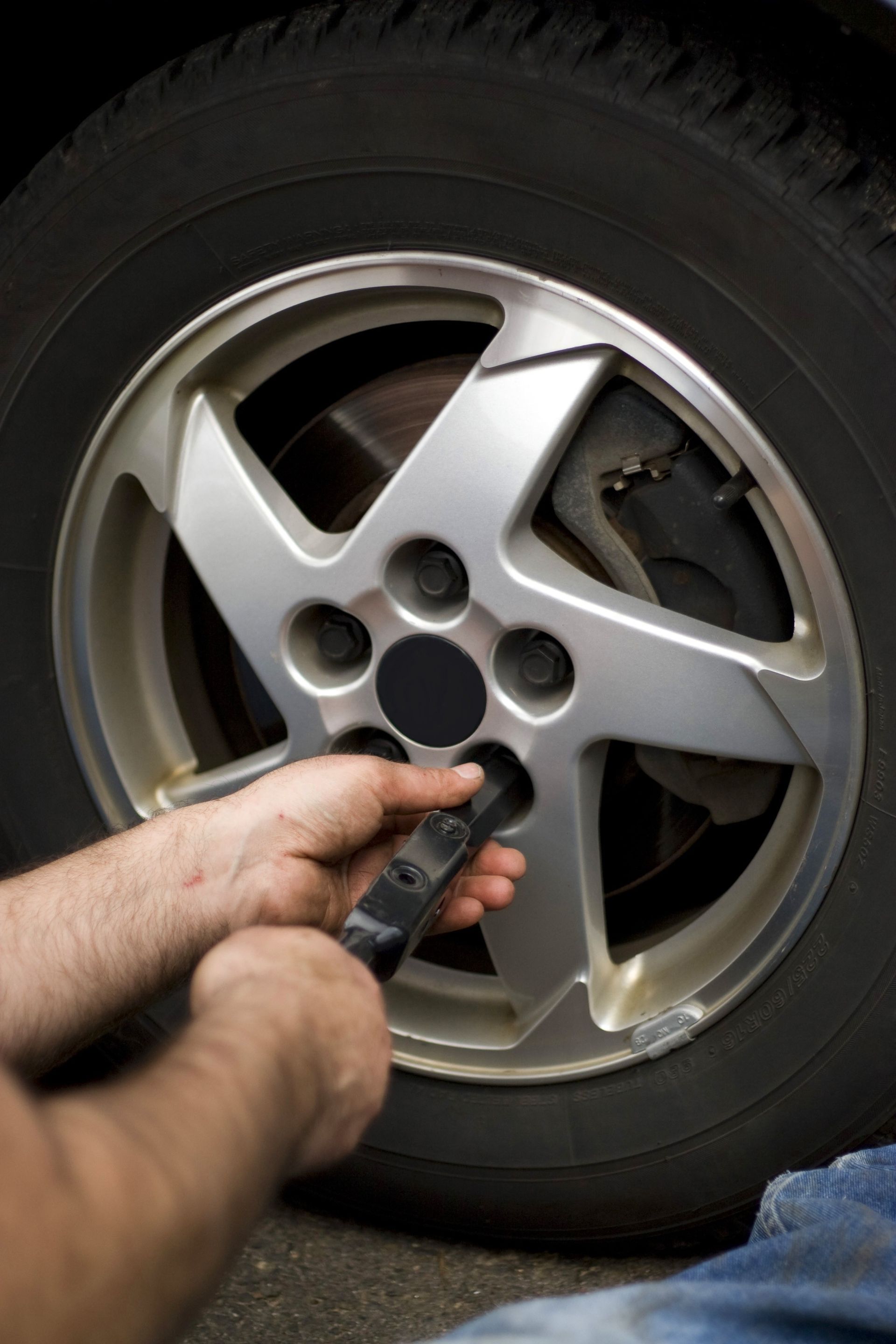 Close-up of a person's hand doing a tire change for a car