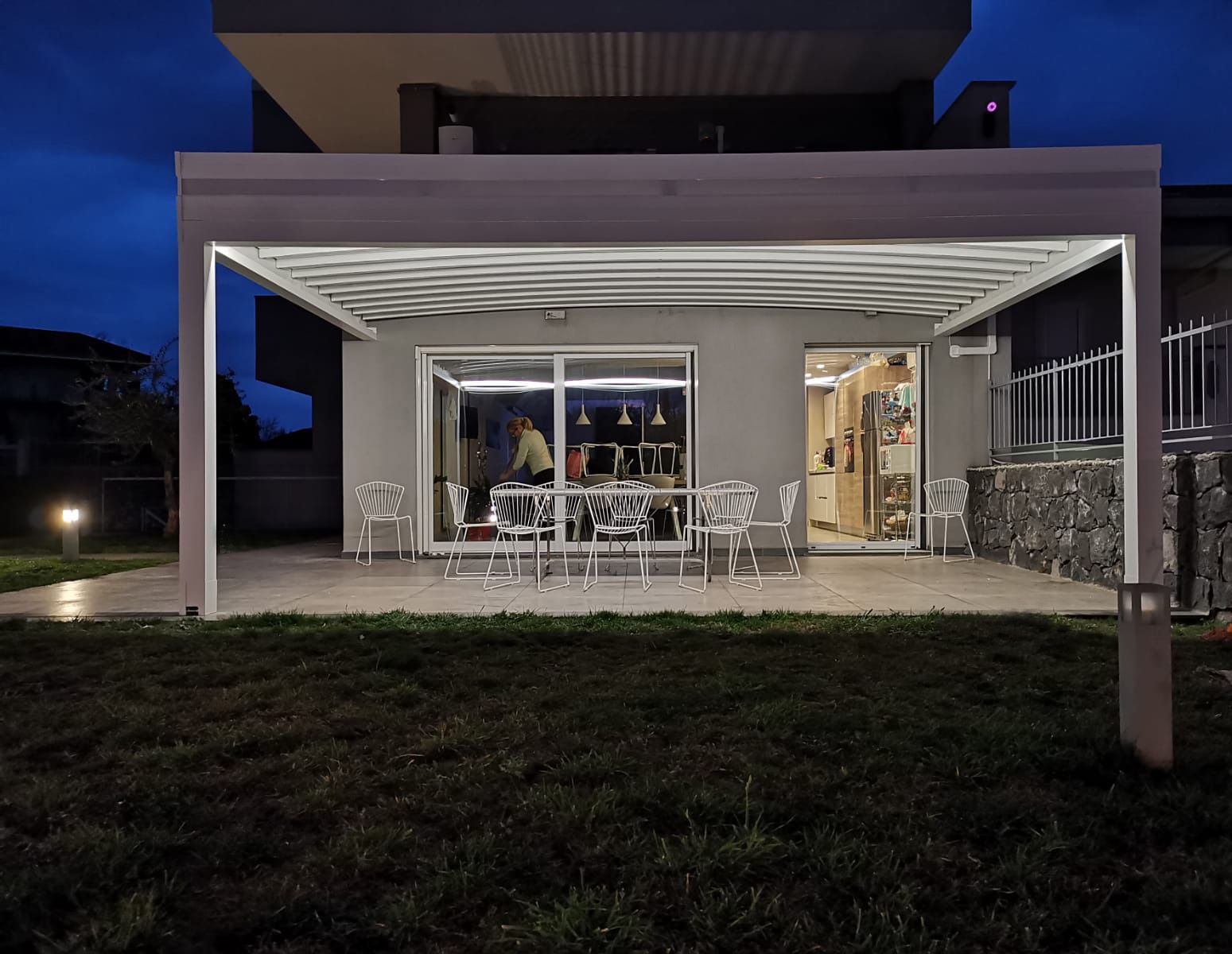 Una casa con un pergolato e un patio di notte