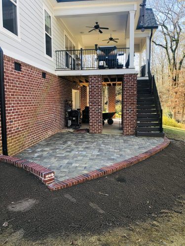 A large brick house with a patio and a balcony.