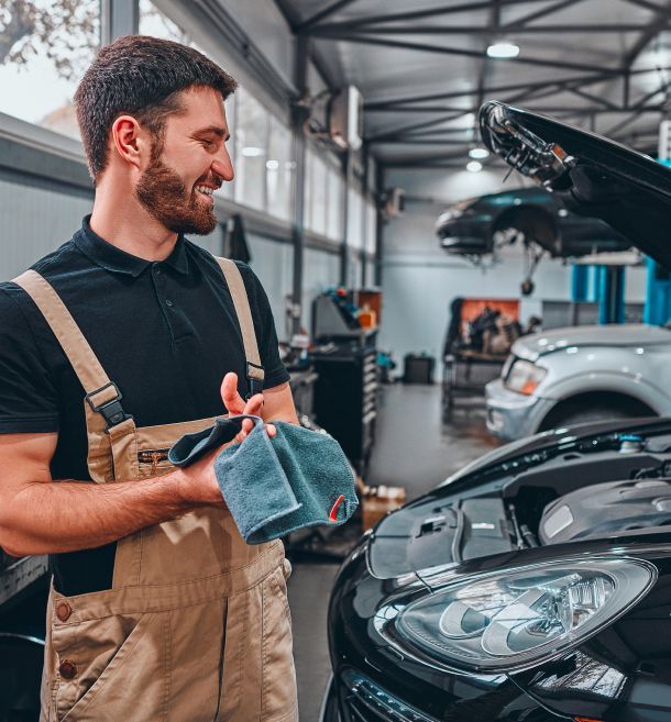 Mechanic wipes his hands after repairing the car | European Autohaus- Frisco TX