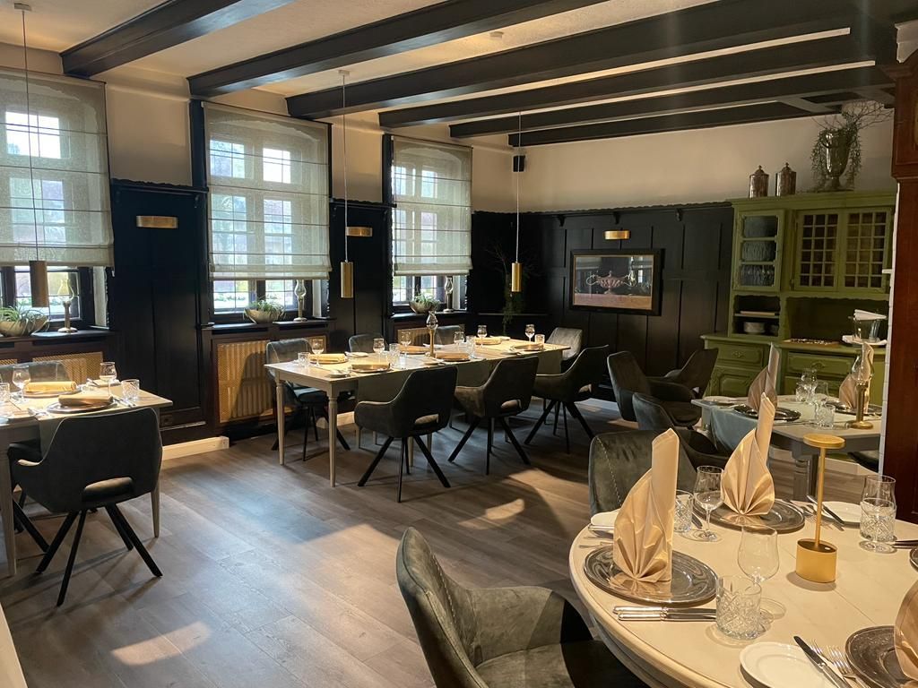 Ein großes Esszimmer mit Tischen und Stühlen für eine Mahlzeit.