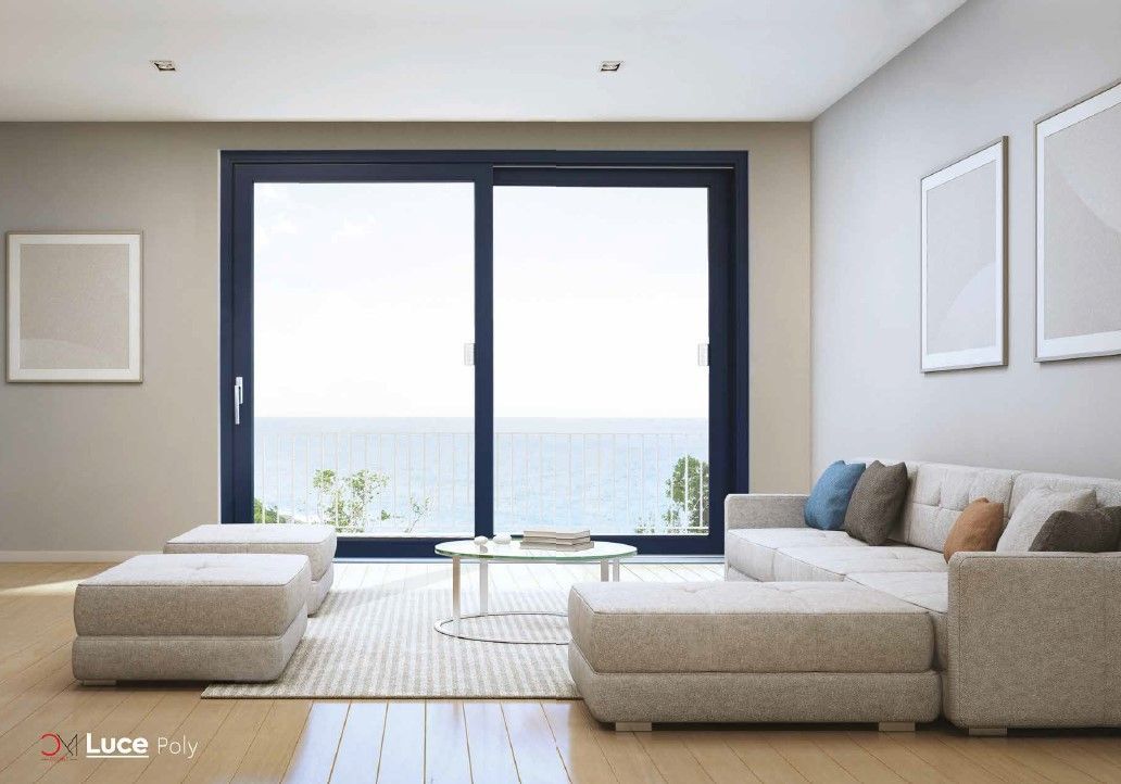 Luminoso soggiorno bianco con vista attraverso le ampie finestre; tavolo da pranzo e sedie, tavolino da caffè in vetro.