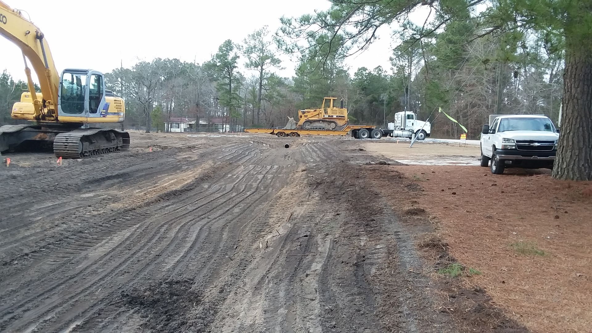 A white truck is parked on the side of a dirt road