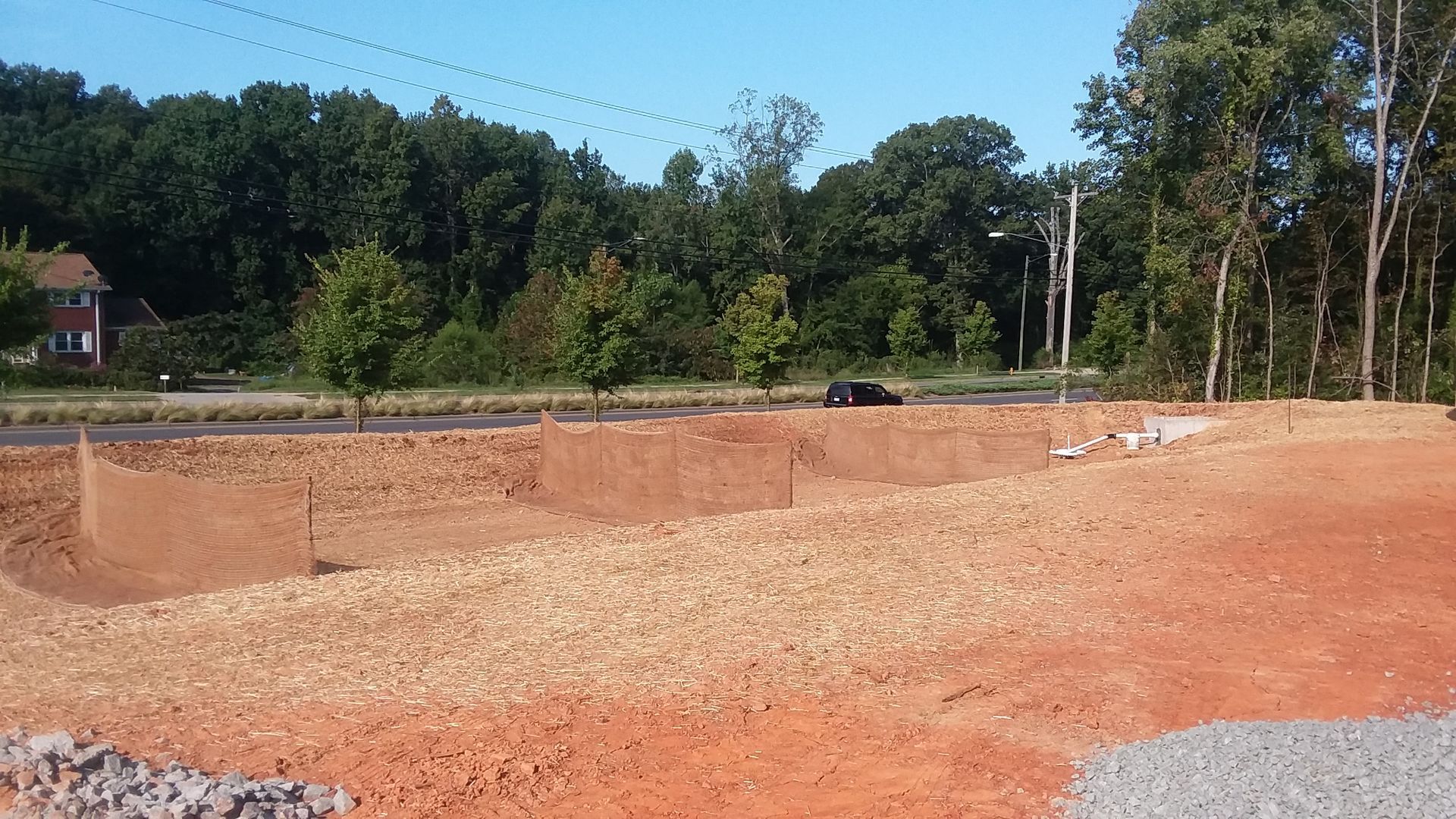 A large dirt field with trees in the background
