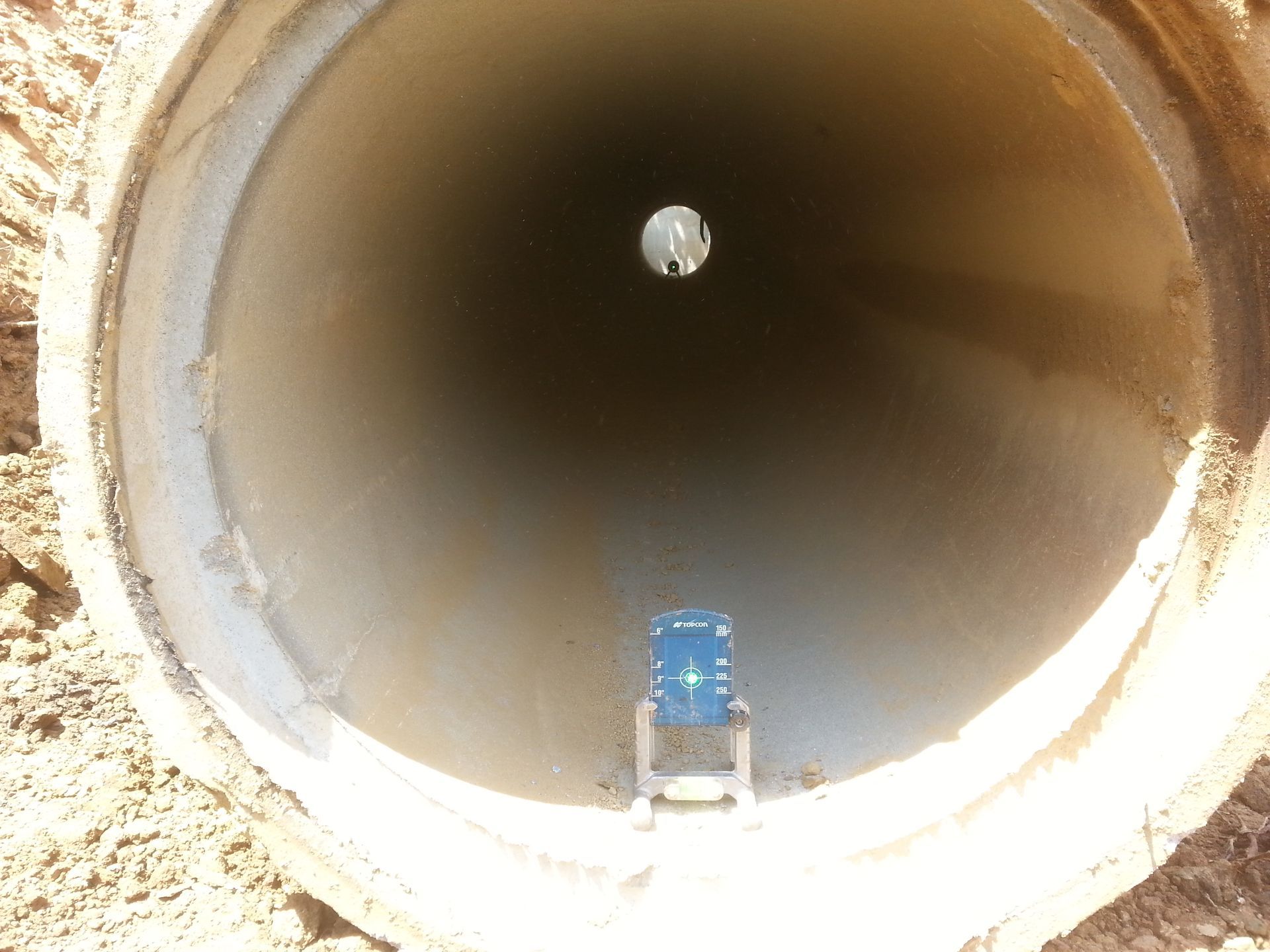 The inside of a concrete pipe with a hole in the middle