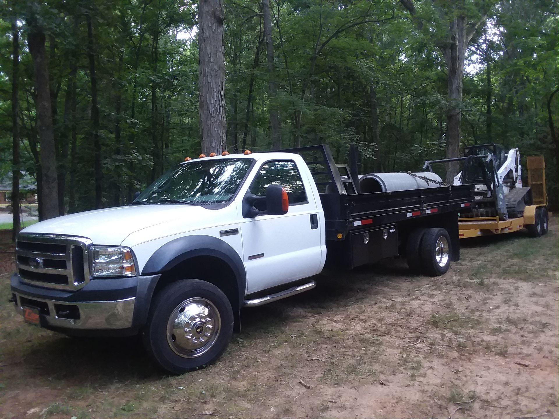 A white truck with a trailer attached to it