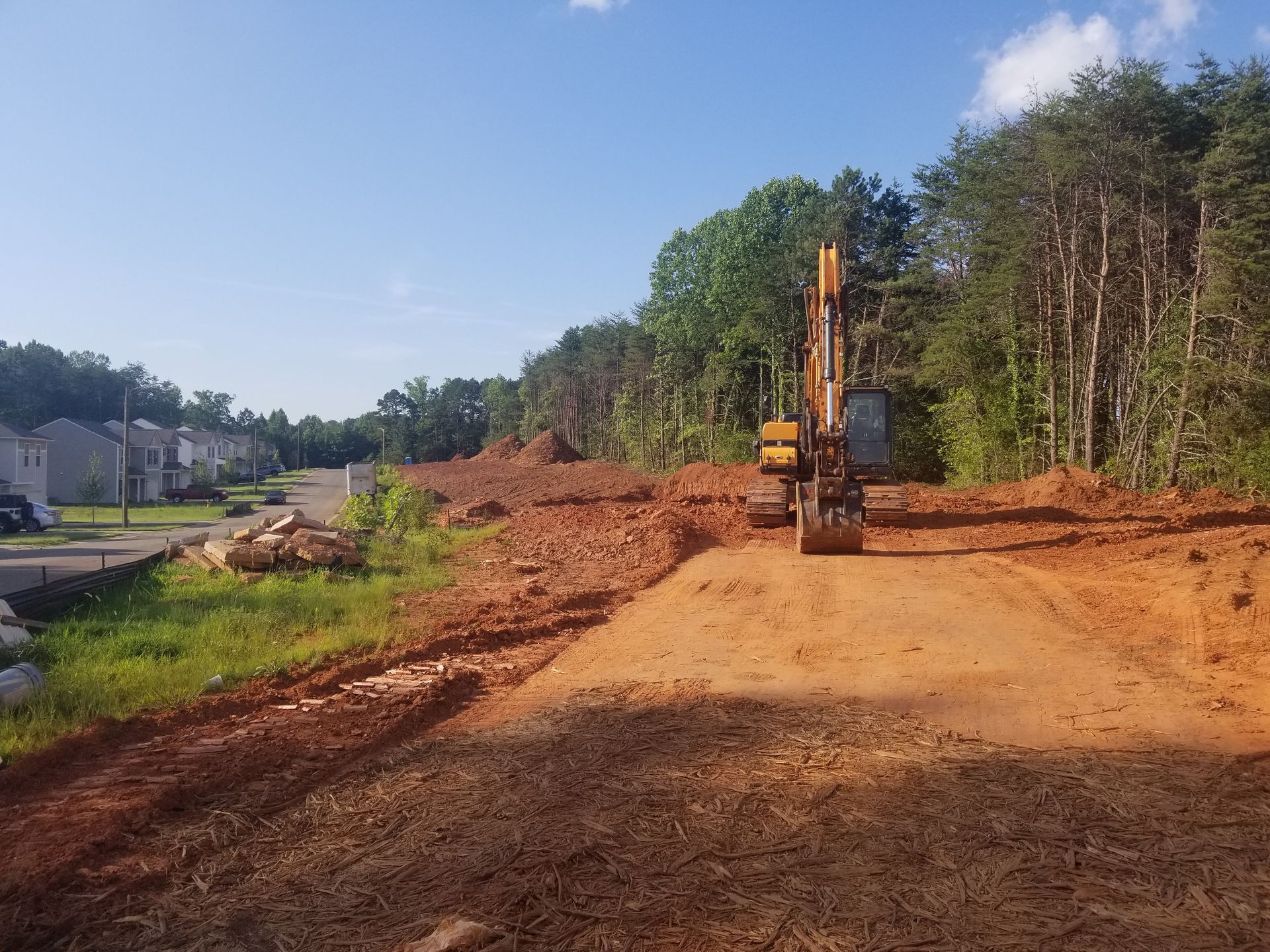 A bulldozer is moving dirt on a dirt road.