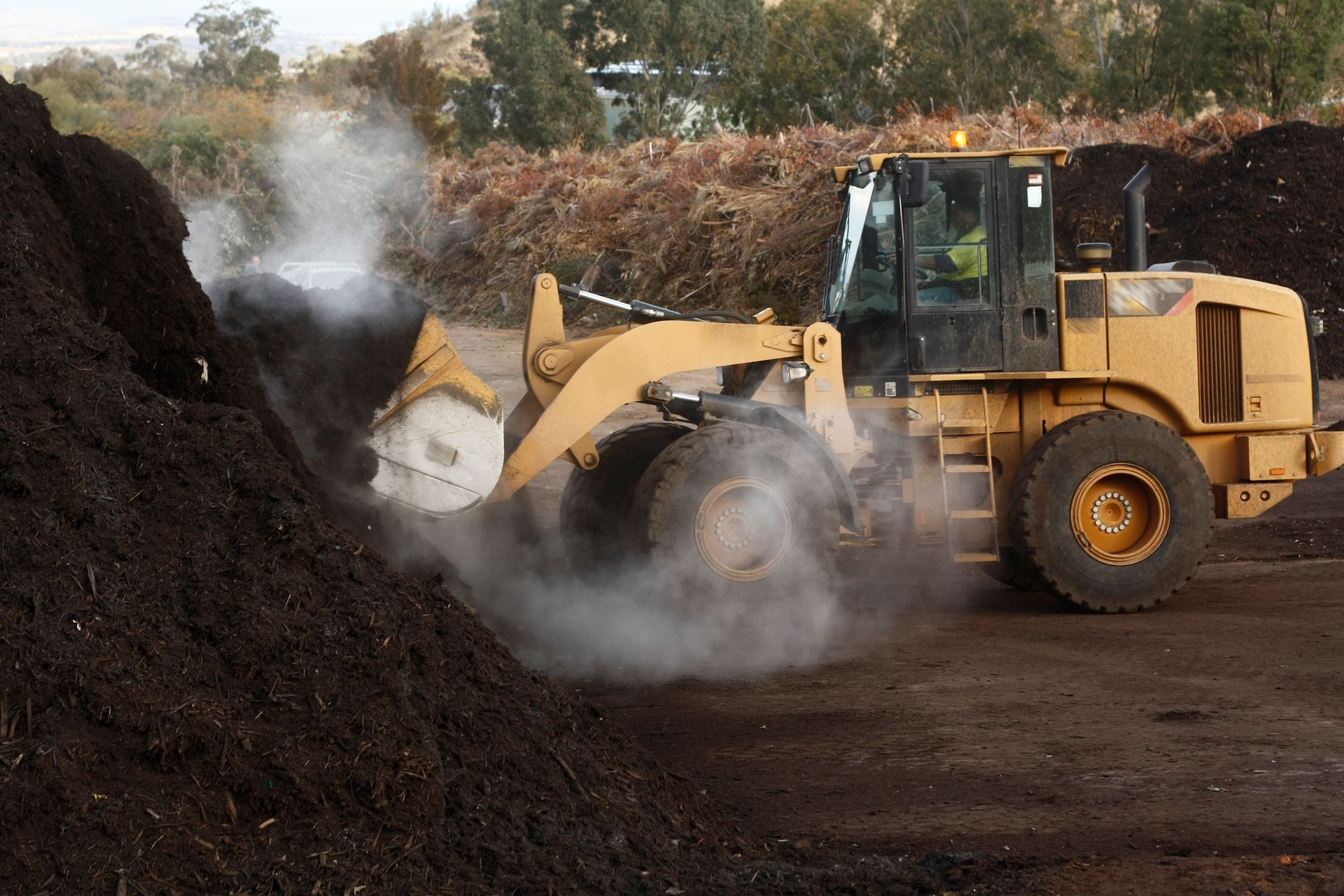 A bulldozer is working on a pile of dirt