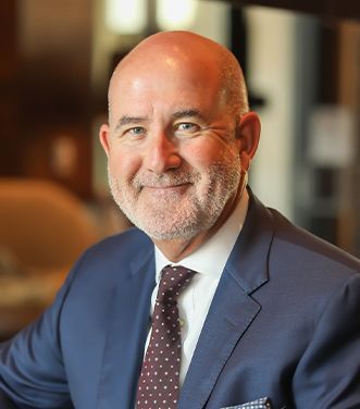 A man in a suit and tie is smiling for the camera.