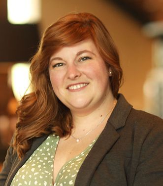 A woman with red hair is smiling for the camera