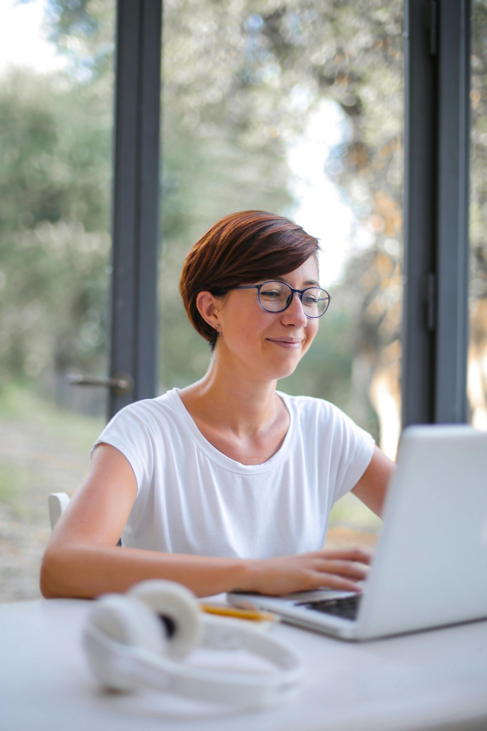 A woman is sitting at a table using a laptop computer.