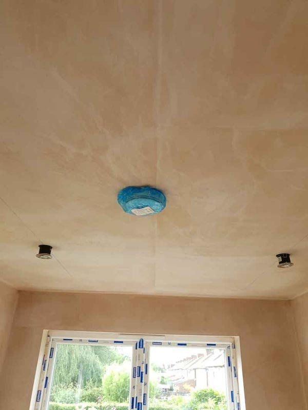 new smoke and heat detector installed covered with plastic