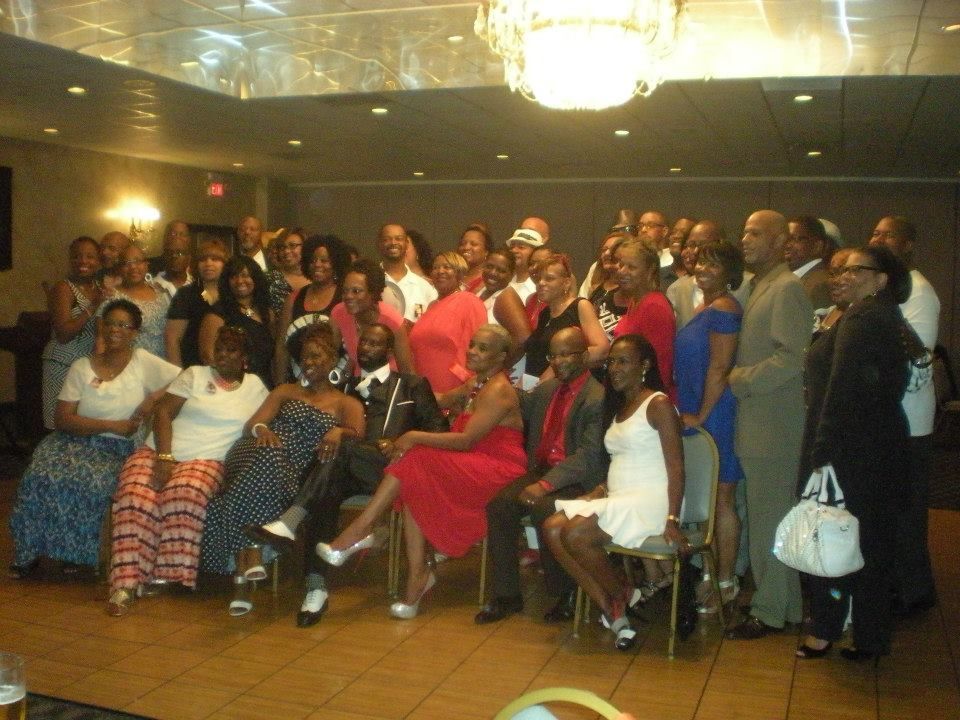 Large group of diverse people at an event, posing for a photo. They are dressed up inside a room.