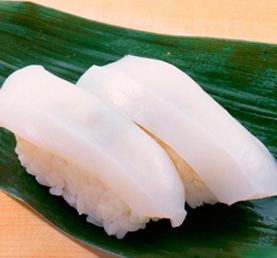 Dos nigiri sushi de calamar blanco sobre una hoja verde.