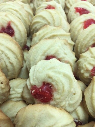 A close up of a pile of cookies with raspberry filling