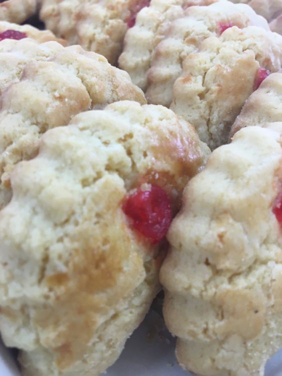 A close up of a bunch of biscuits with cherries on them