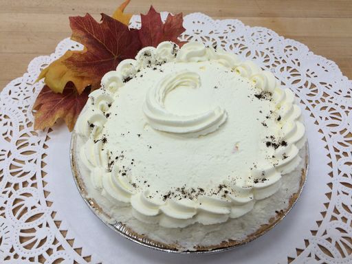 A pie with a letter c on it is sitting on a table.