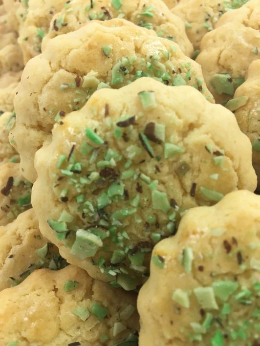 A bunch of cookies with green sprinkles on them