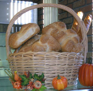 A wicker basket filled with bread and pumpkins