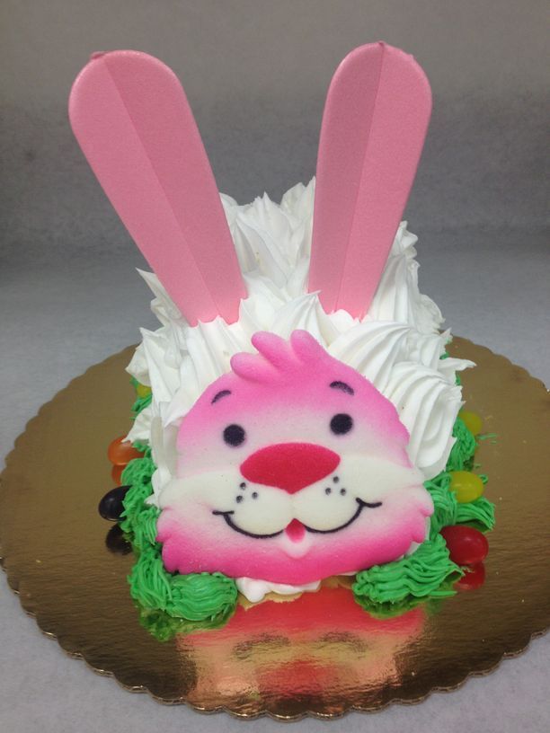 A cake decorated to look like a bunny with pink ears