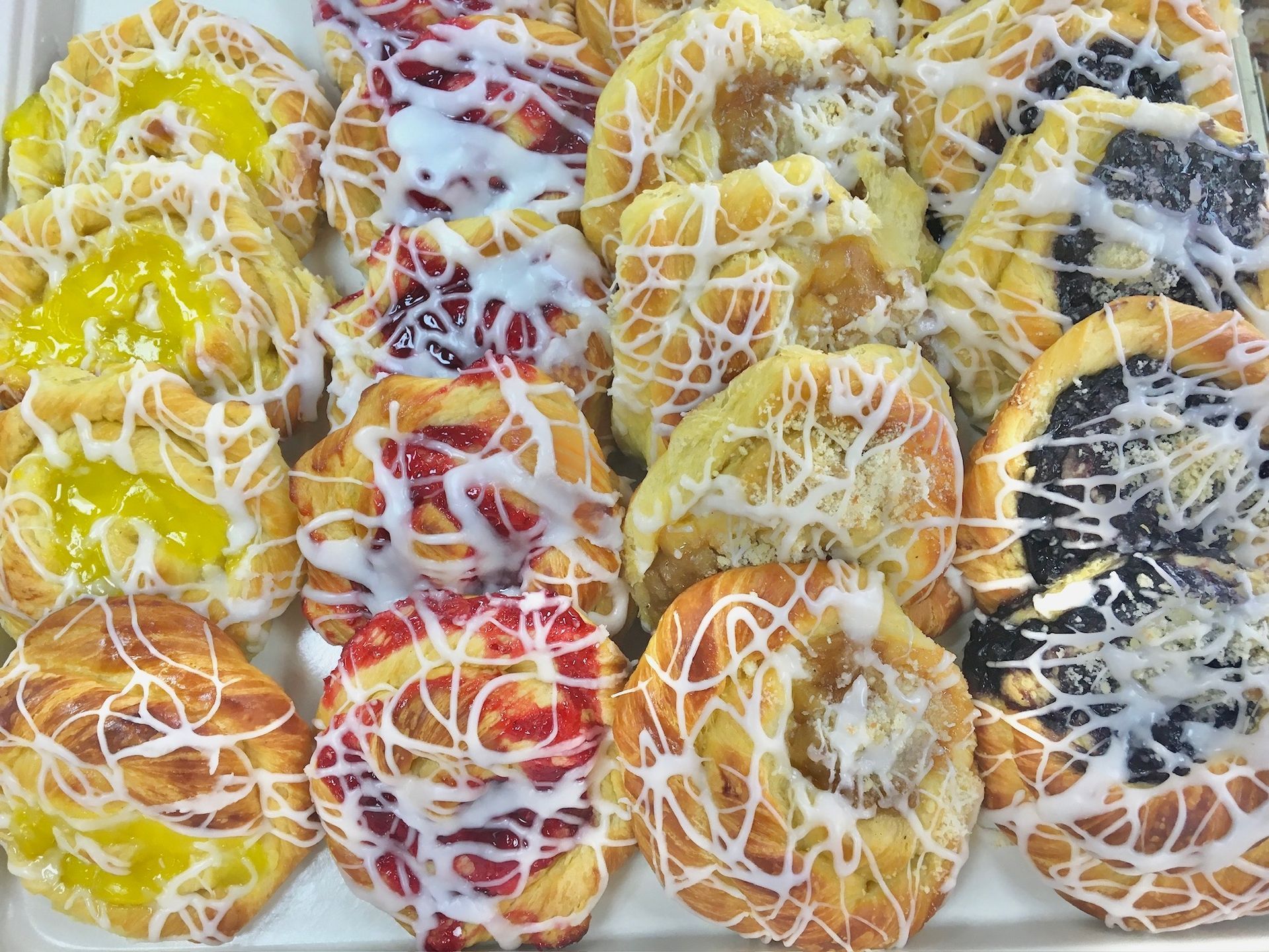 There are many different types of pastries on the tray.