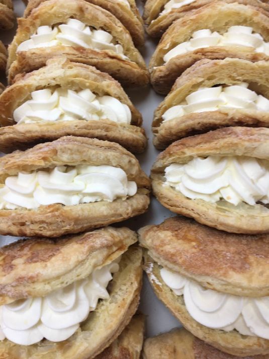 A bunch of pastries with whipped cream on them