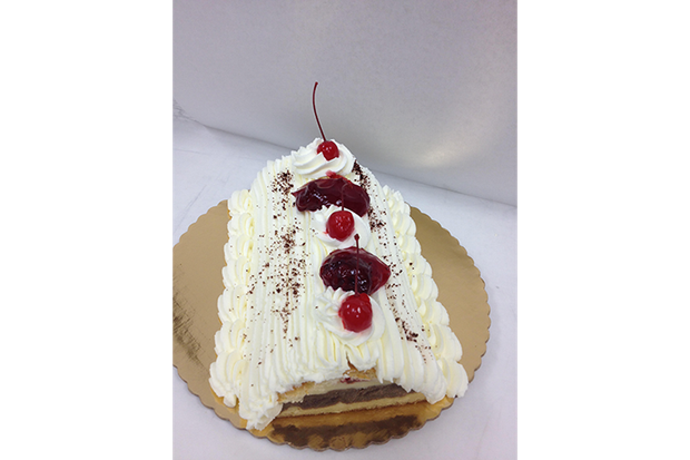 A slice of black forest cake with whipped cream and cherries on top.