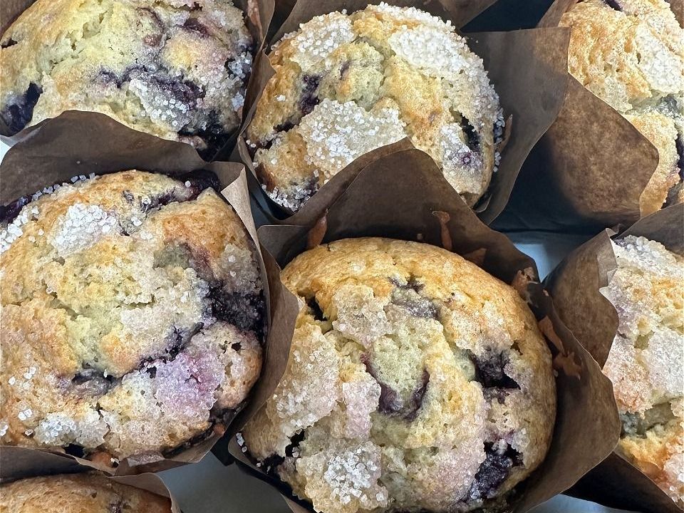 A bunch of blueberry muffins are sitting on a table.
