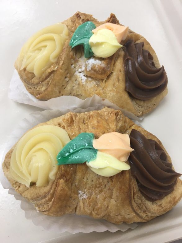 Two croissants with different flavors of frosting on them