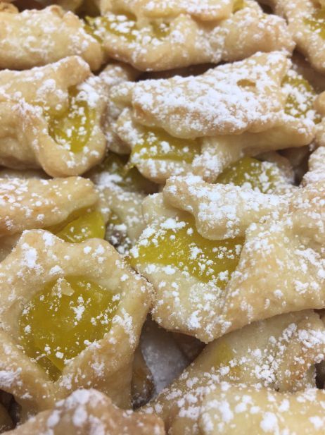 A close up of a pile of cookies with powdered sugar on top.