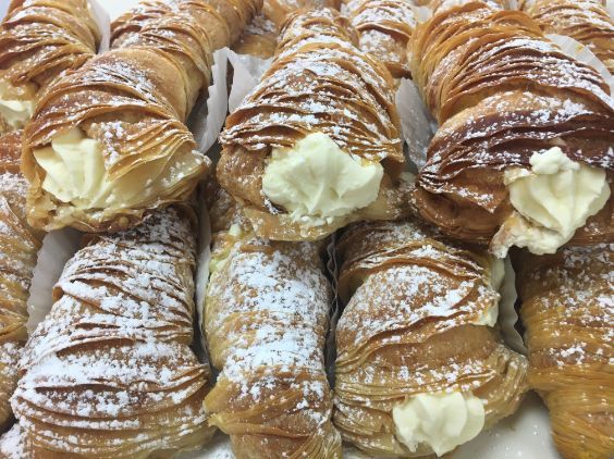 A close up of a bunch of pastries with powdered sugar on them.