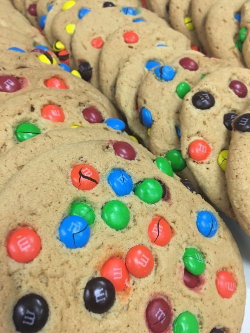 A bunch of cookies with m & m 's on them