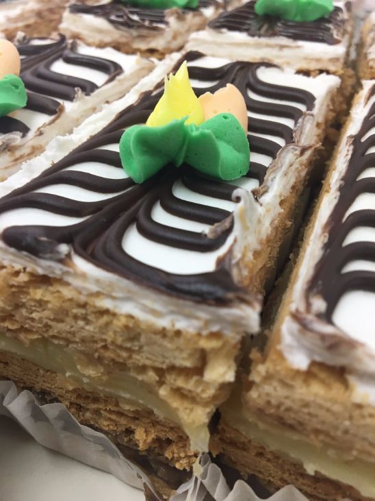 A close up of a cake with a green flower on top